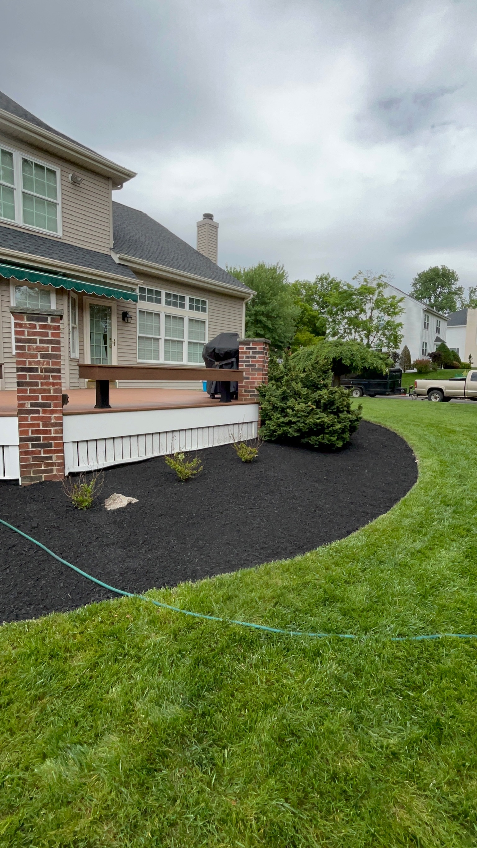 Black mulch beds along the side of a house