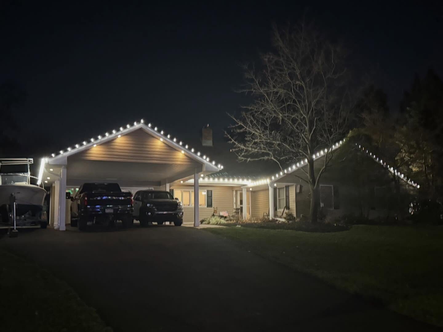 White lights along a carport gable and ranch home roofline