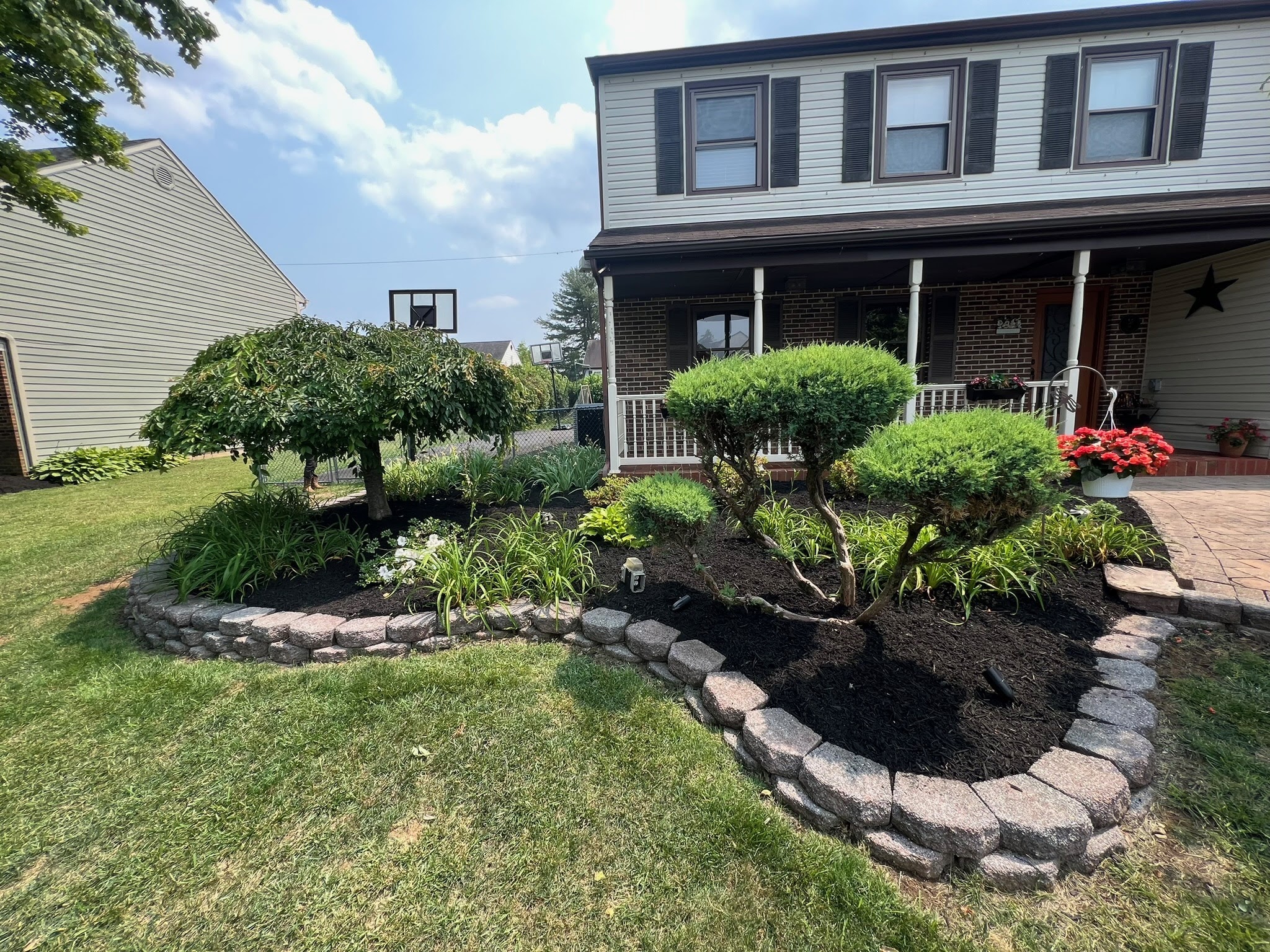 Mulch beds with decorative brick border and trees